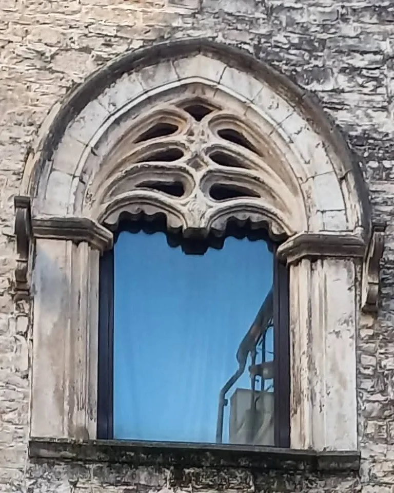 Bifora gotica in pietra su un muro di un palazzo storico di Trani