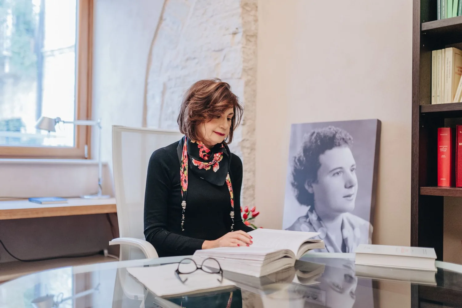 Franca Maria Lorusso nel suo studio a Trani, alla scrivania, mentre studia un volume