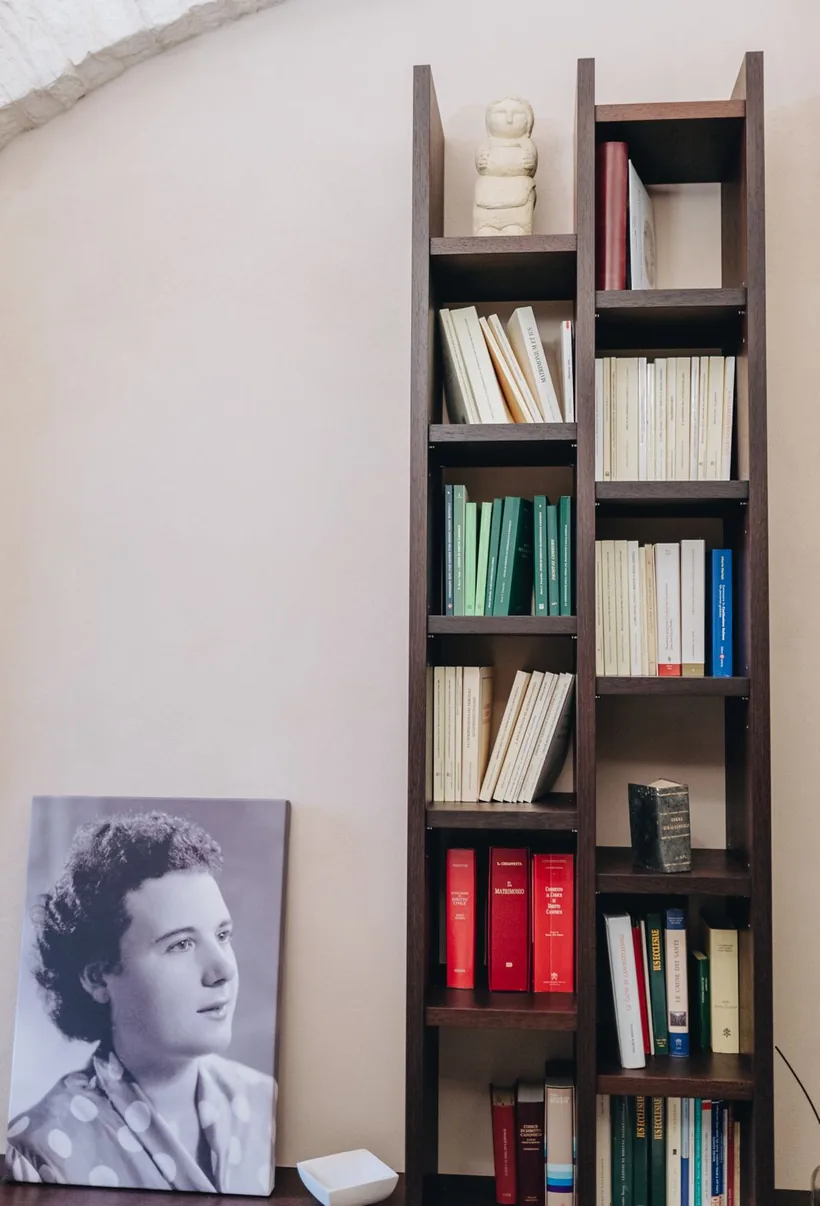 La libreria di diritto canonico nello studio, accanto al ritratto della Serva di Dio Santa Scorese