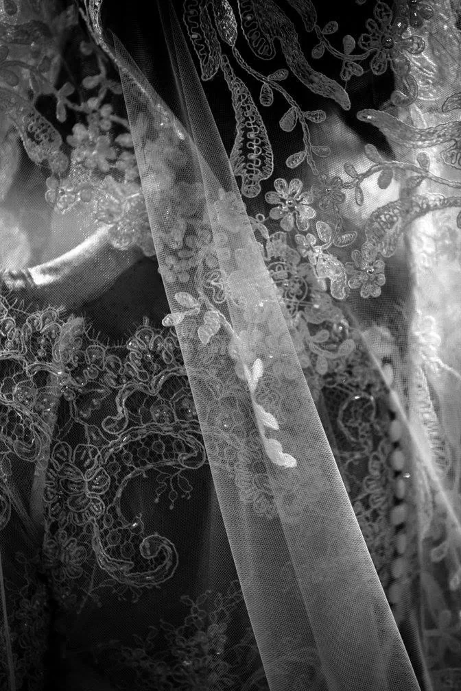 Dettaglio in bianco e nero di un velo da sposa in pizzo